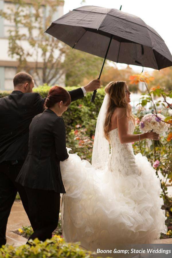Fairy Godmother Cassandra holding umbrella for bride during wedding procession